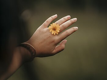 Foto: Blume am Finger als Zeichen für einen Ring